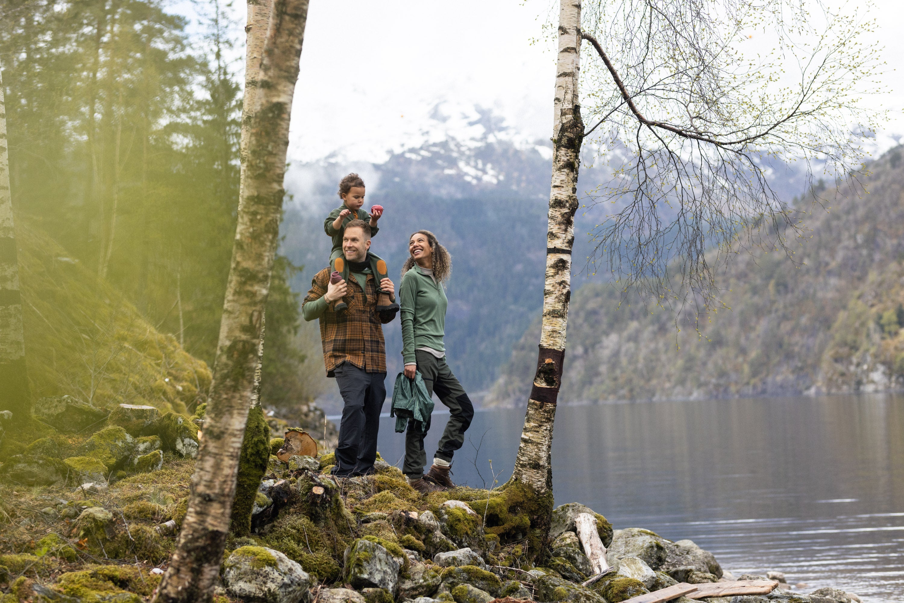 Familie i skogen med Janus Classic merinoull trøye og hettegenser i farge oliven